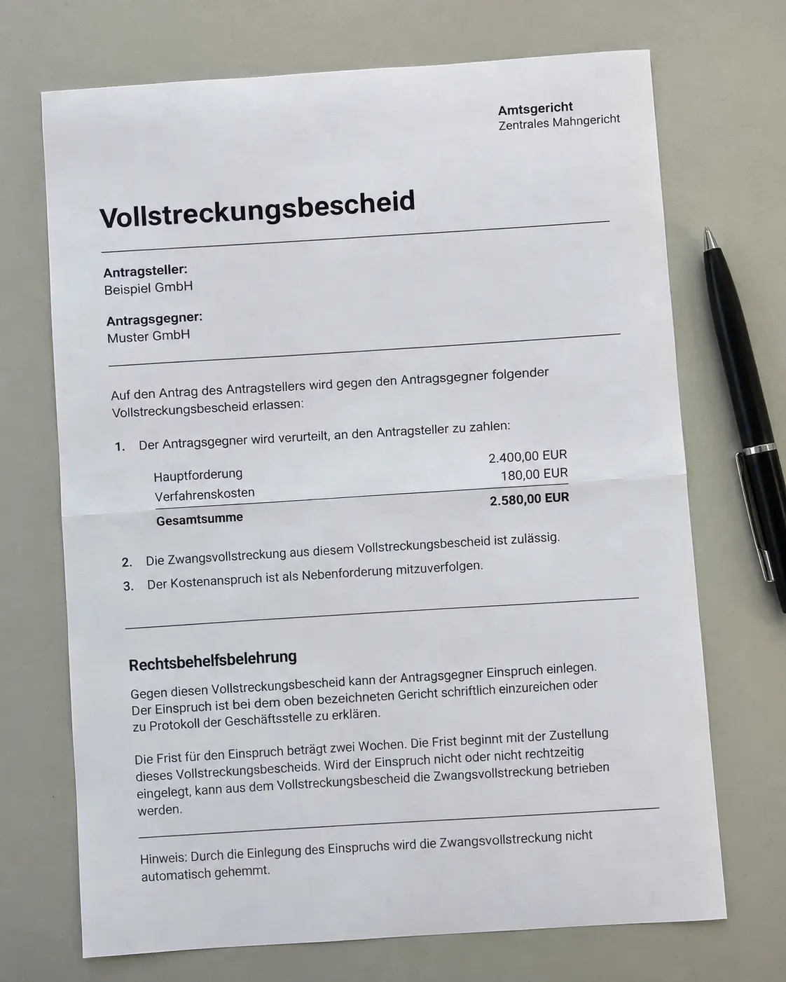 Vollstreckungsbescheid des zentralen Mahngerichts über eine offene Forderung auf einem hellen Tisch, daneben ein Kugelschreiber